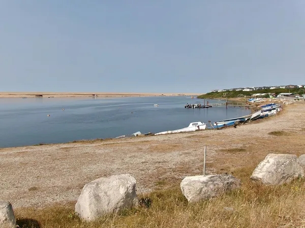 Shingle shore and shallow water at the southern end of the Fleet Lagoon, with Chesil Beach beyond