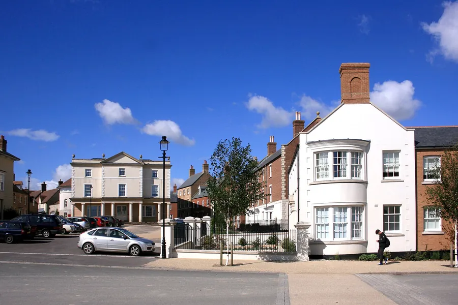 Traditional-style houses, tall chimneys and a Georgian-style civic building in Poundbury, Dorchester
