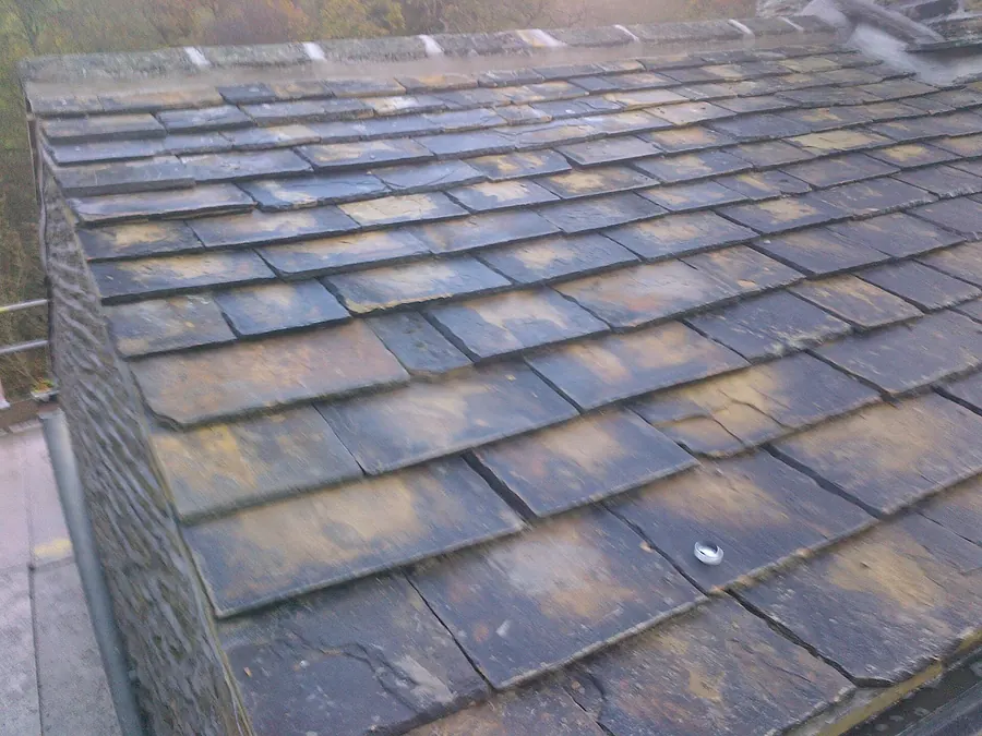 Close-up of a natural stone slate roof showing the thickness and texture of each slate