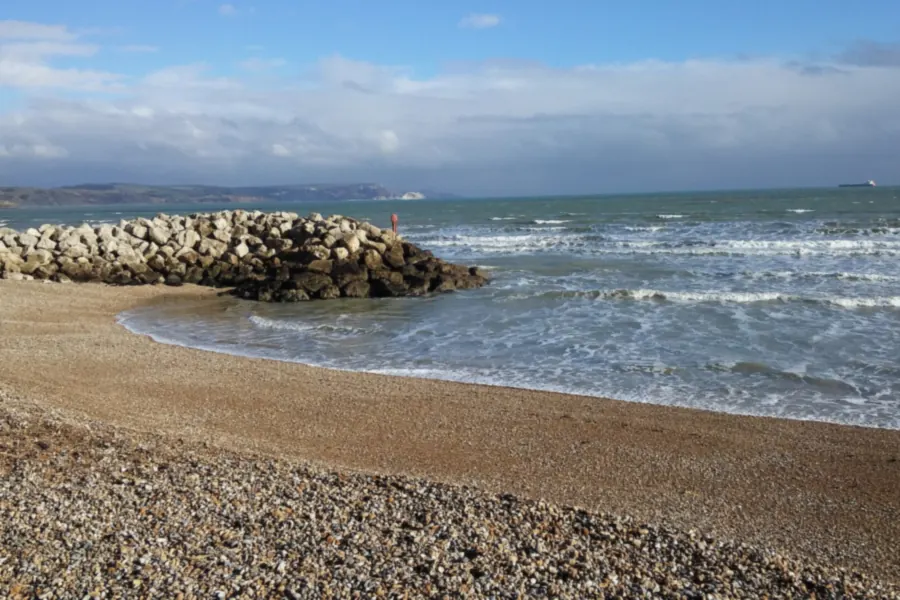 Rough sea and rock groyne on the beach at Weymouth Bay after a winter storm