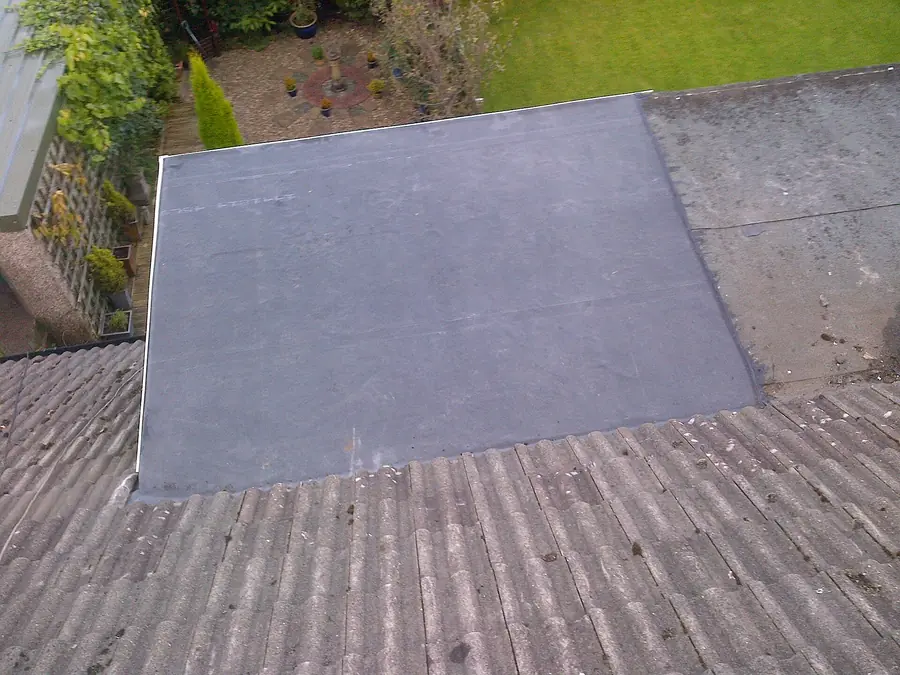 EPDM rubber flat roof on an extension meeting an older concrete tiled roof