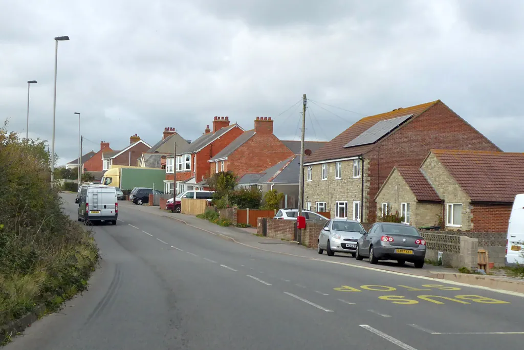 Row of brick and rendered houses with pitched roofs on Chickerell Road